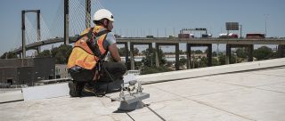 Fall arrest lifeline with bypass anchors on hot deck roof