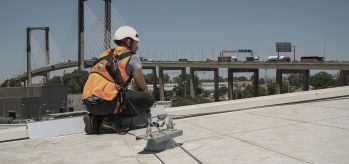 Fall arrest lifeline with bypass anchors on hot deck roof